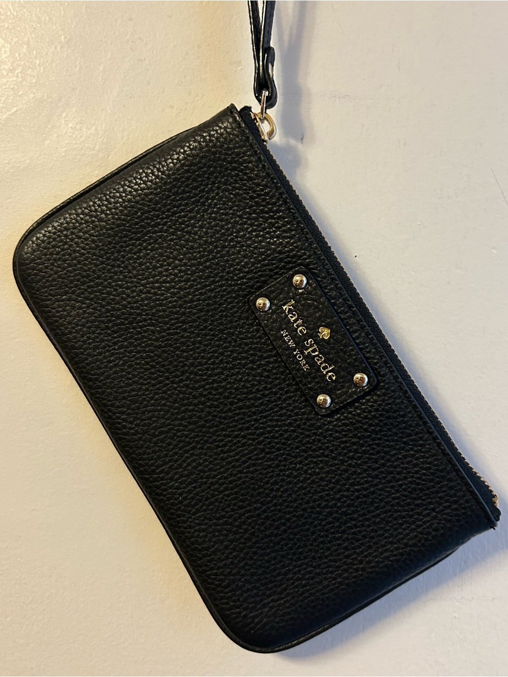 kate spade black pebbled leather wristlet with gold-tone logo